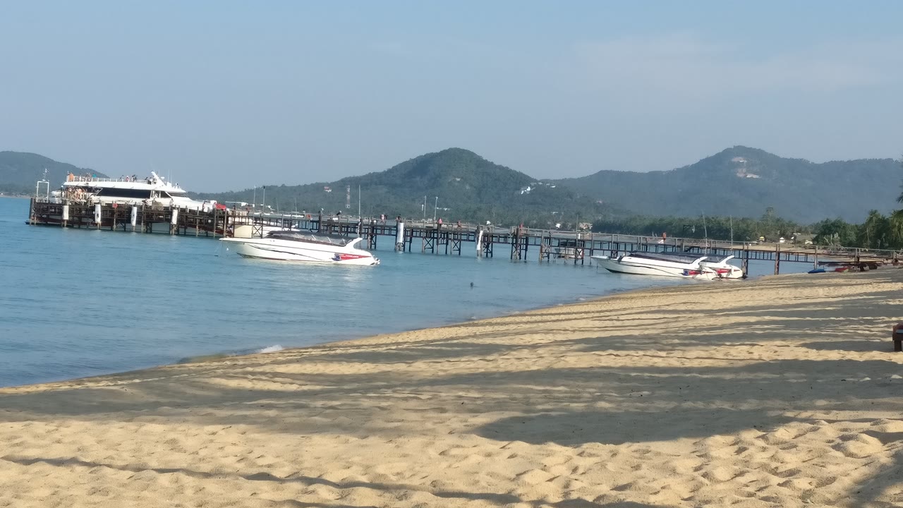 Playa de arena con lanchas rápidas y un muelle de madera en Mae Nam, costa norte de Koh Samui, Tailandia